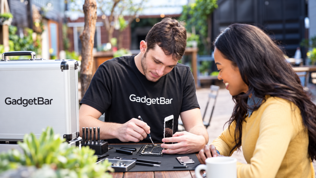 GadgetBar service illustration showing a technician repairing a phone beside a customer.